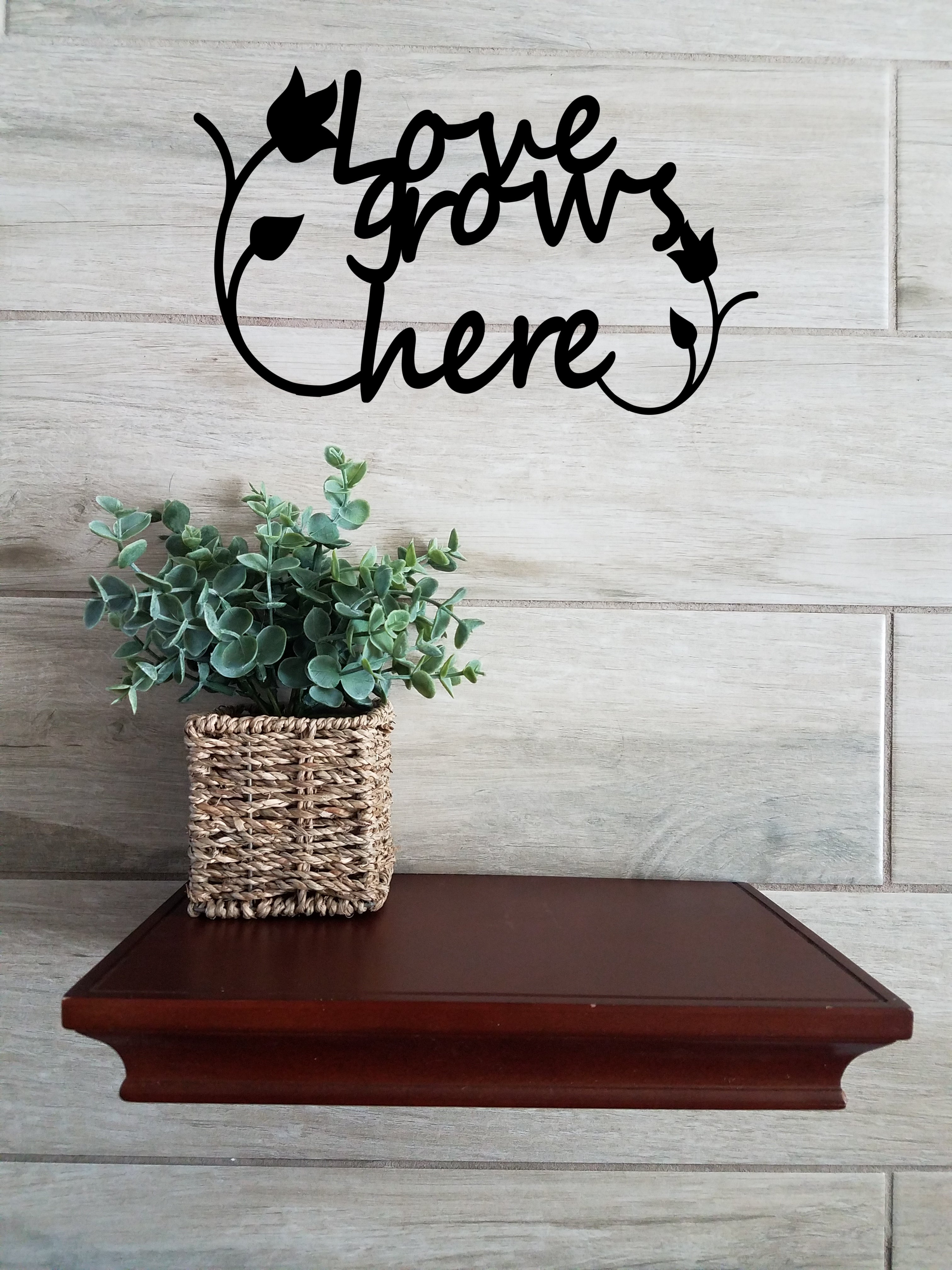 Black metal wall art sign. Love grows here with two tulip surrounding script.s